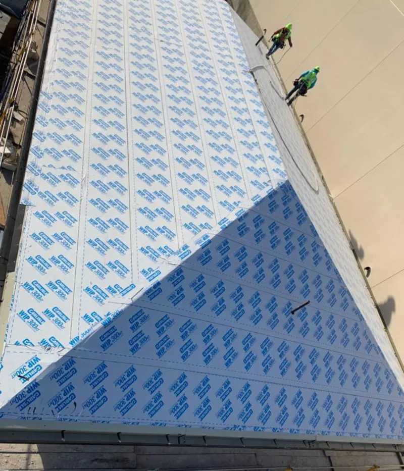 Professional roofers installing underlayment on a metal roof in Corona